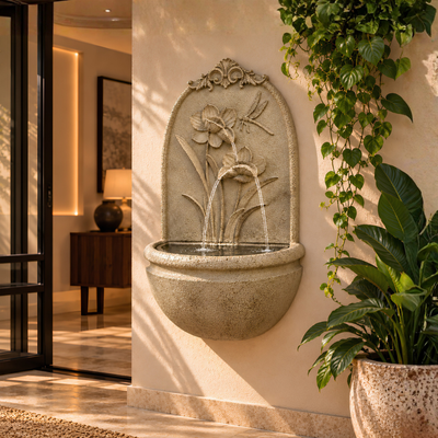 Floral wall mounted water feature with flower and dragonfly design, stone-look finish and rounded basin for indoor or outdoor use